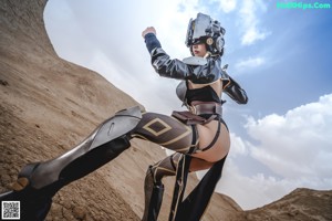 A woman in a futuristic outfit holding a gun.
