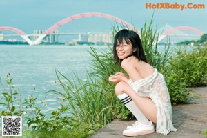 A woman in a pink top and white shorts holding a baseball bat.