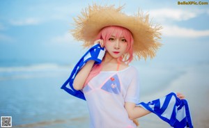 A woman in a straw hat is standing in the water.