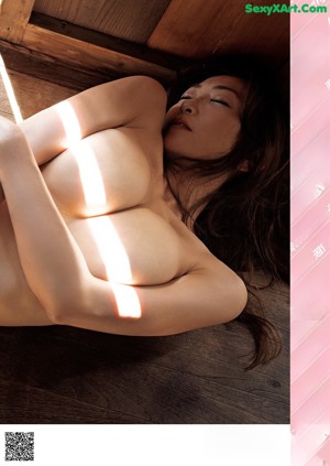 A woman laying on the floor with her hands on her stomach.