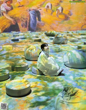 A woman sitting on top of a bed covered in flowers.