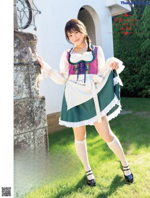 A woman in a pink bra and green skirt posing for a picture.