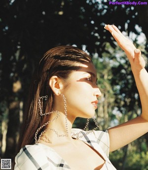 A woman leaning against a tree in a park.
