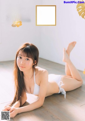 A woman in a white bikini posing for a magazine.