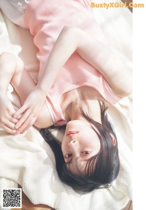 A young woman laying on top of a wooden table.