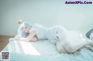A woman in a white dress sitting on the ground.