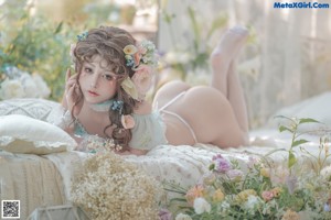 A woman in a blue and white lingerie posing in front of a window.