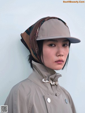 A woman in a pink top and beige pants posing for a magazine.