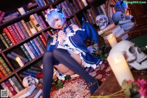 A woman in a blue and white dress holding a skull.