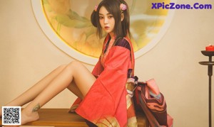 A woman in a colorful kimono sitting on a wooden bench.
