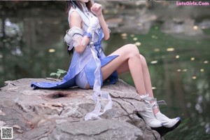 A woman in a blue dress is posing for a picture.