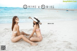 A couple of naked women standing next to each other on a beach.