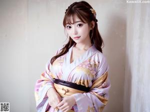 A woman in a blue kimono posing in a field of flowers.