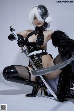 A woman in a black and white outfit holding a sword.