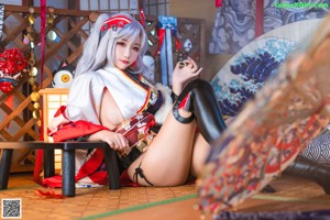 A woman in a kimono sitting on a couch.