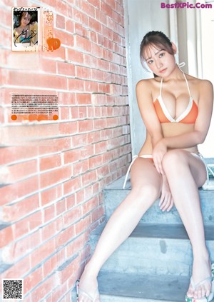 A woman in a bikini sitting on a tree with bubbles.