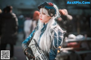 A woman in a blue and black outfit holding a gun.