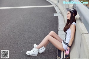 A woman riding a skateboard down a street.